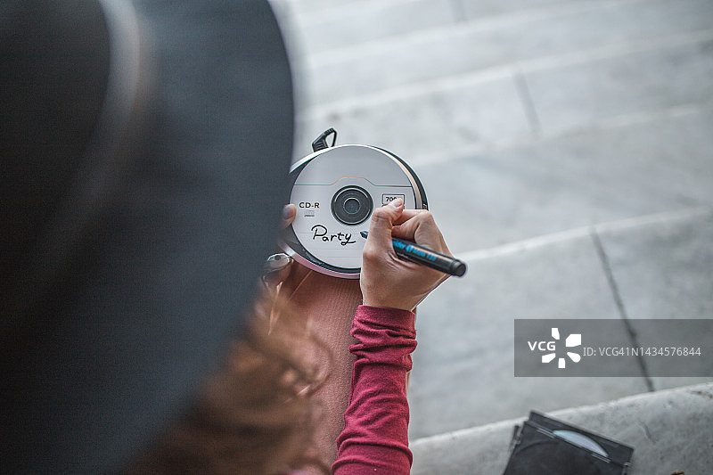 一位女士用毡尖笔在CD上写字图片素材