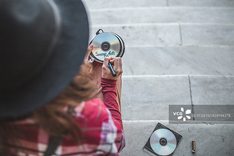 年轻女子用记号笔在光盘上写字图片素材