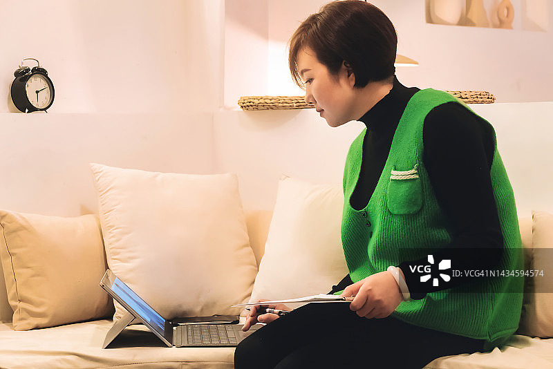 年轻女子在家中使用笔记本电脑支付在线账单图片素材