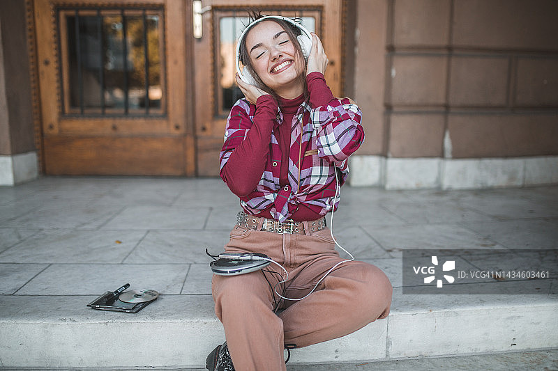 年轻女子喜欢用迷你光盘播放器听音乐图片素材