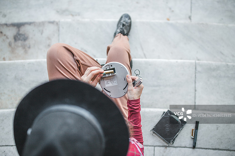 俯视：女子安装CD播放器电池图片素材