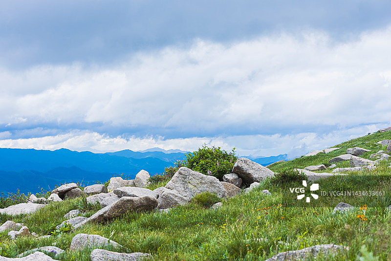 天空下山坡和草地上的岩石图片素材