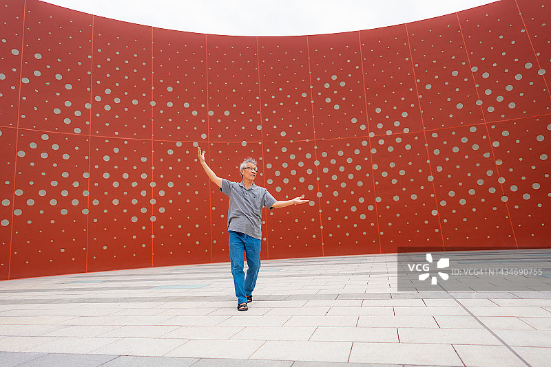 老人在红墙前跳舞图片素材