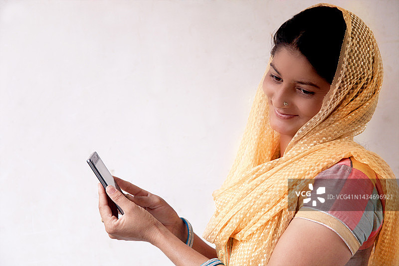 在家手持手机的快乐女性肖像图片素材