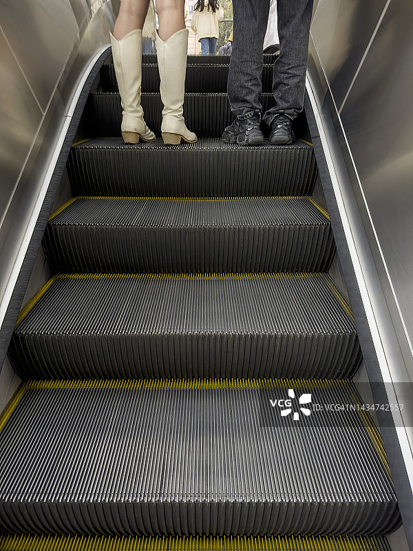 一对情侣站在自动扶梯上图片素材