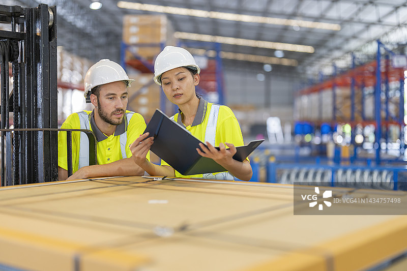 仓库工人讨论工厂仓库发货计划图片素材