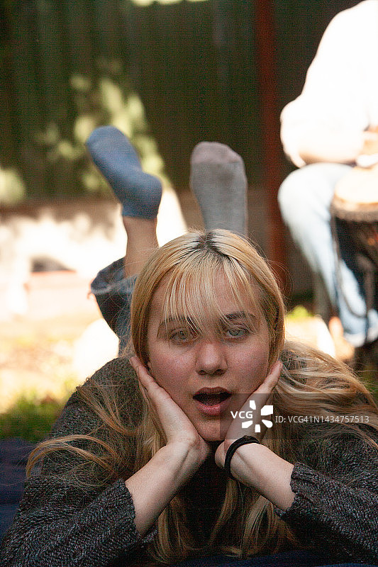 托腮女人与躺卧少女：自信展现不对称袜子图片素材