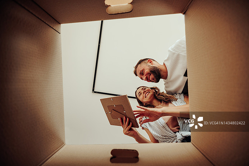 情侣在新家打开相框图片素材