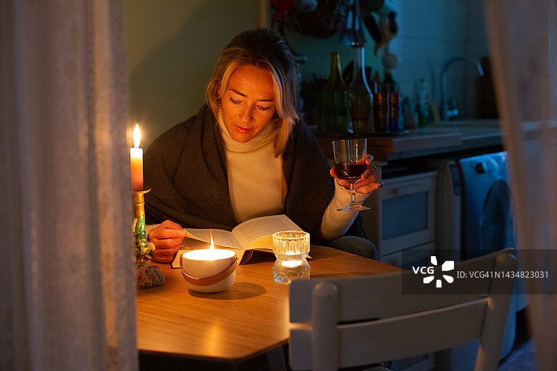 在烛光下读书，避免用电的女人图片素材