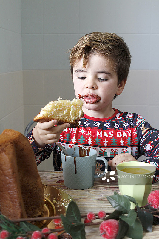 男孩在圣诞节当天吃早餐图片素材