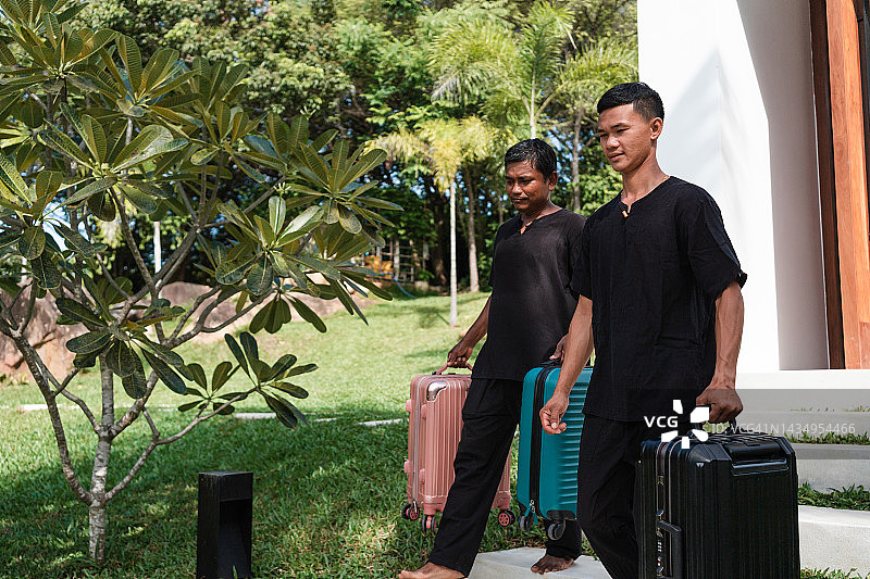 行李员将手提箱搬到豪华别墅图片素材