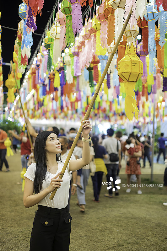 快乐的亚洲女人手持灯笼，这是泰国北部一年一度的挂灯笼传统图片素材