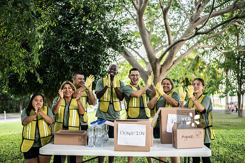 志愿者在公园庆祝并击掌的肖像，包括有特殊需求的年轻女性图片素材