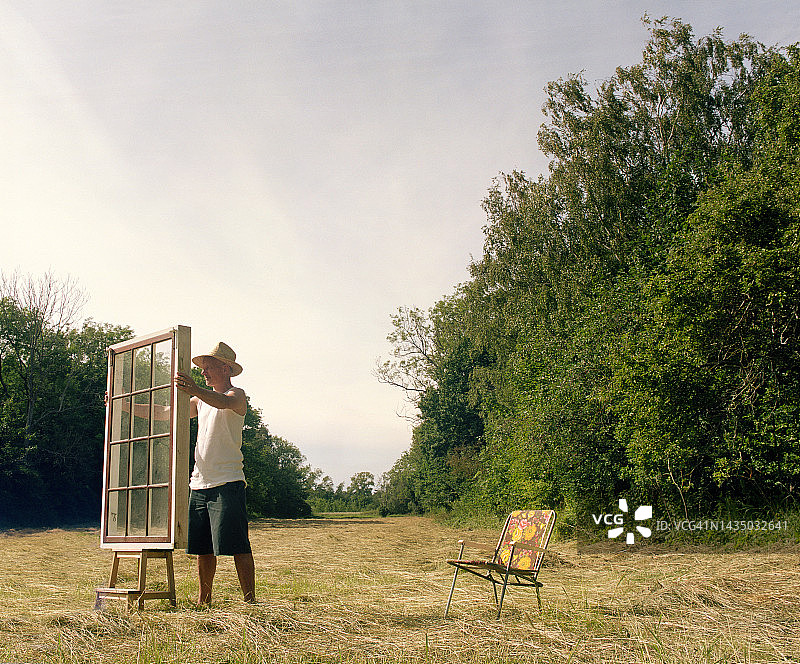 男人在田野里拿着窗户图片素材