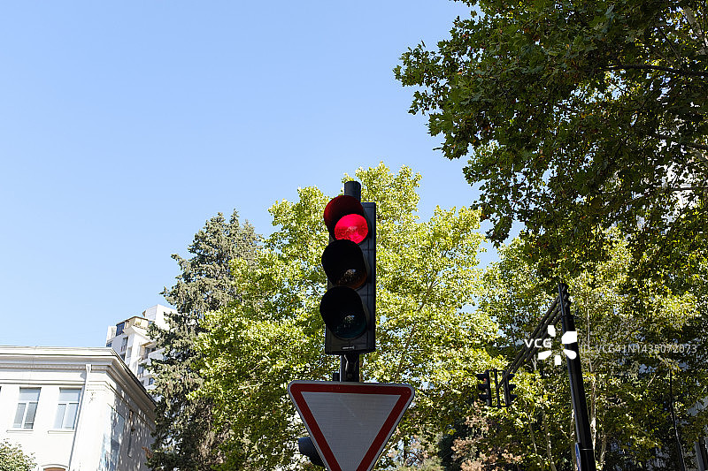 红色交通信号灯特写，背景为居民高层建筑，提示交通规则，禁止车辆通行。图片素材