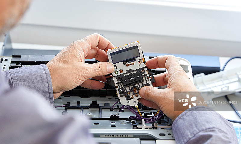 技术人员更换电脑打印机中的零件的特写图片素材