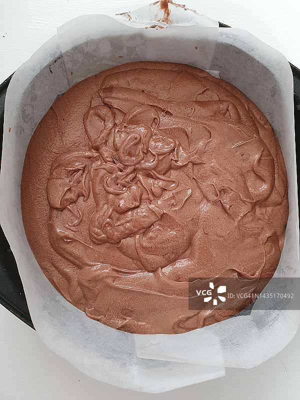 白色背景上的巧克力蛋糕混合物和烤盘中的巧克力蛋糕面糊图片素材
