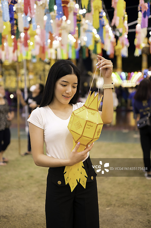 快乐的亚洲女人手持灯笼，这是泰国北部一年一度的挂灯笼传统图片素材