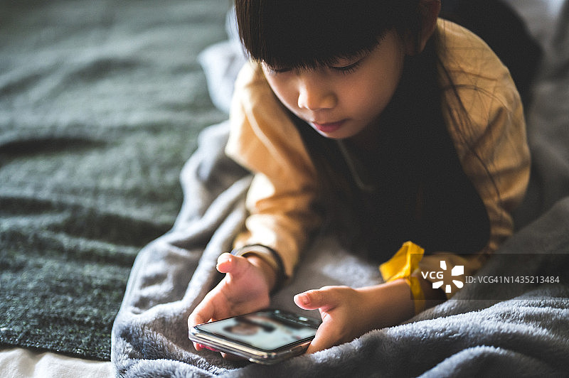 可爱的中国少女在家用手机进行视频通话图片素材