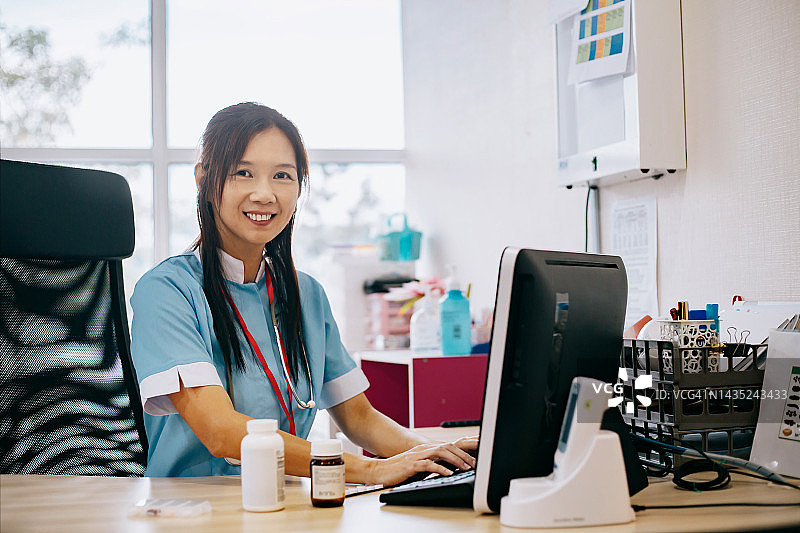 使用电脑的微笑护士的肖像图片素材