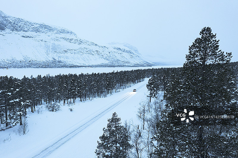 汽车行驶在穿越雪林的盘山公路上图片素材