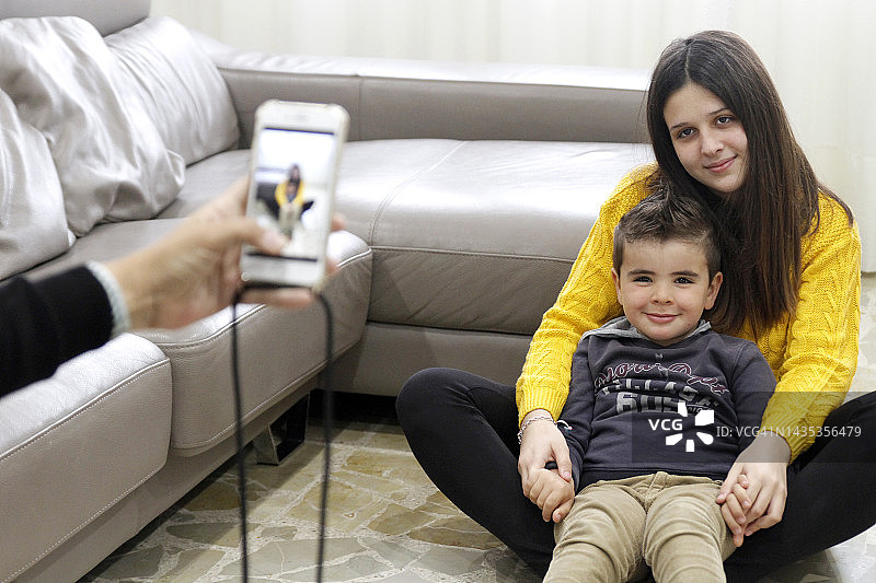 女人在家给孩子们拍照图片素材