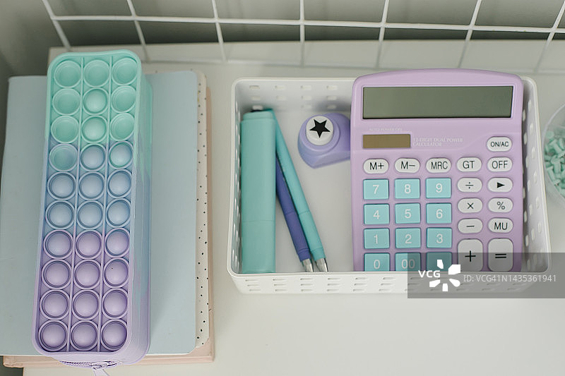 白色桌面上的白色收纳盒、计算器和学习用品俯视图图片素材