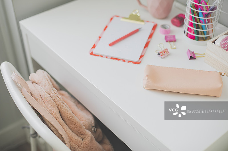 白色时尚女性家庭办公室工作区，配有毛绒背包、铅笔盒、剪贴板、笔、回形针。俯视，平铺。家庭办公室。回到学校图片素材