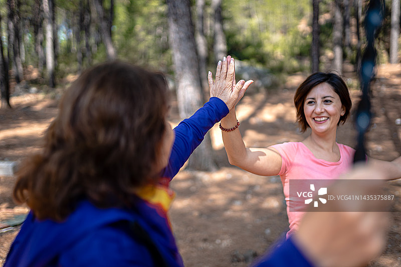在森林中与教练一起玩滑索的年长妇女图片素材