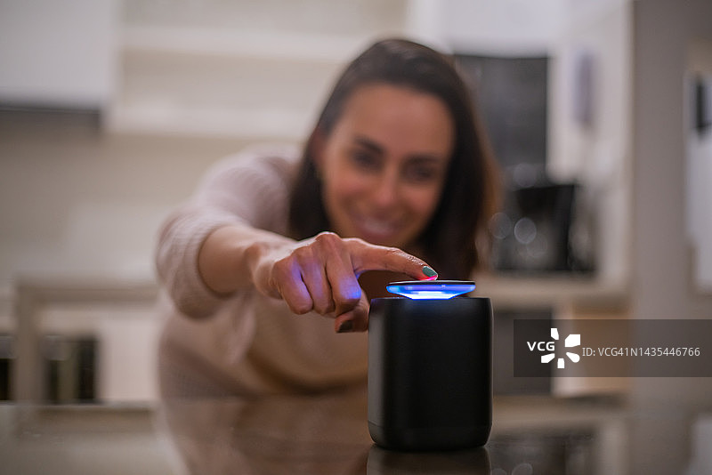 快乐的女人在家用扬声器听音乐图片素材