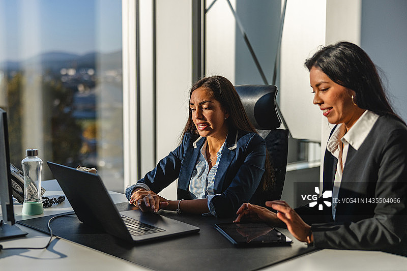 两位西班牙裔女高管在总部讨论未来计划图片素材