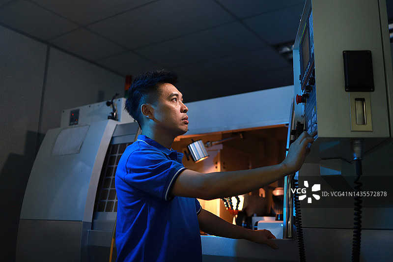 在工厂操作机器的亚洲工程师图片素材