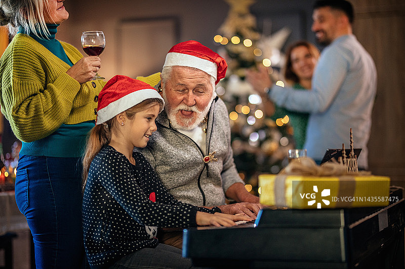 多代家庭欢聚庆祝圣诞节，弹奏钢琴图片素材