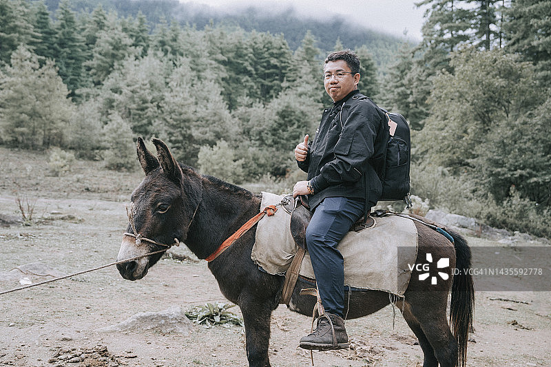 中国游客骑骡子准备徒步前往不丹虎穴寺图片素材