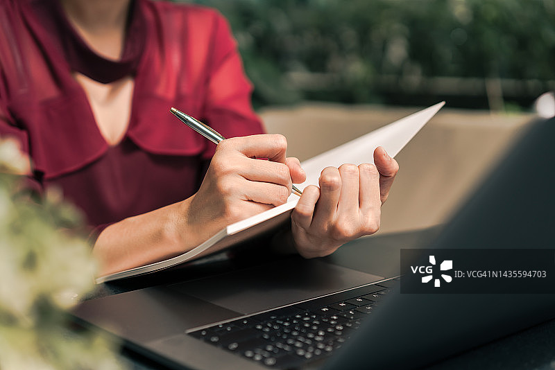 在咖啡馆拿笔在书上写作的文案撰写人图片素材