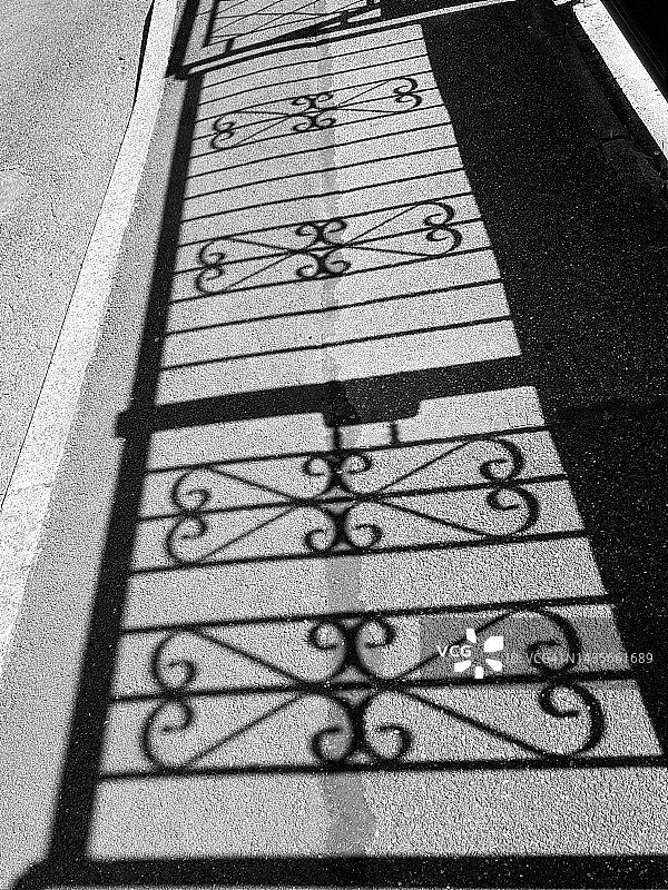 光影静物：沥青路上华丽栏杆的轮廓图片素材