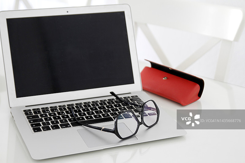 办公桌上的笔记本电脑和眼镜特写图片素材