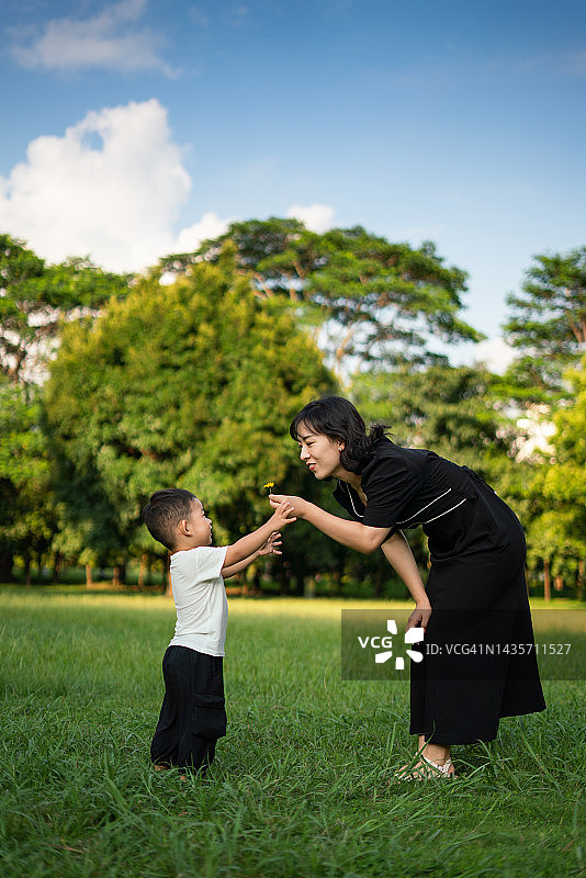 妈妈和可爱的小男孩在草地上玩耍图片素材