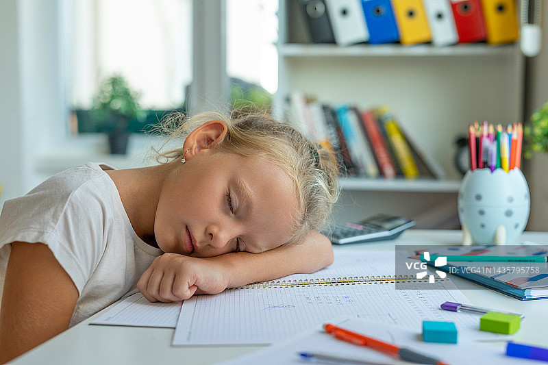 疲惫的女孩趴在桌子上睡觉图片素材