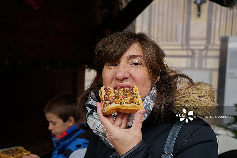 和孩子们一起散步吃巧克力华夫饼的女人图片素材