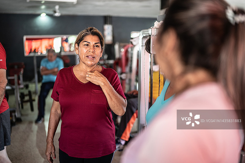 老年妇女在健身房和朋友聊天图片素材