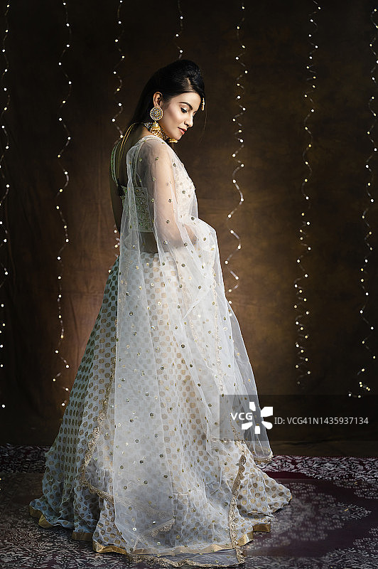 穿着印度传统民族服装、珠宝套装、衬衫和杜帕塔的美丽印度女孩的肖像图片素材