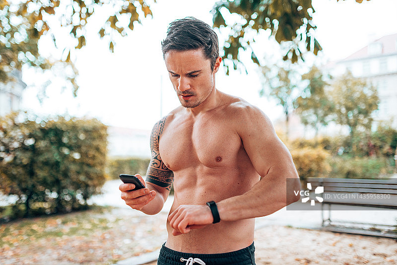 男人检查健身应用并锻炼图片素材