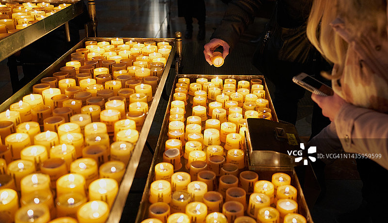 在教堂内点燃蜡烛的人们图片素材