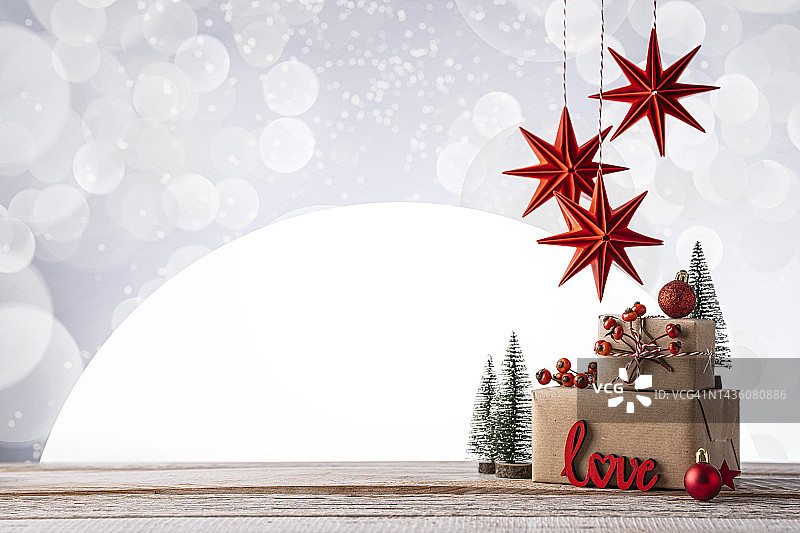 木质背景上的小礼品盒、圣诞装饰和节日灯图片素材