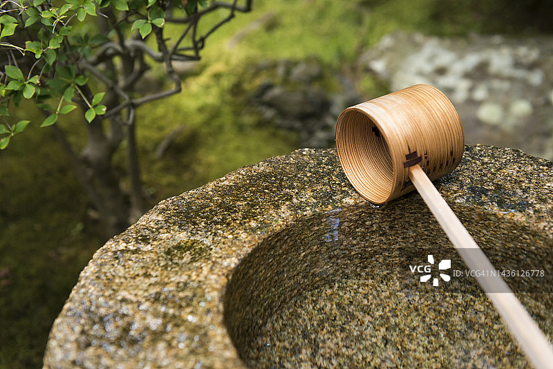 日本蹲踞石钵与木制水勺特写图片素材