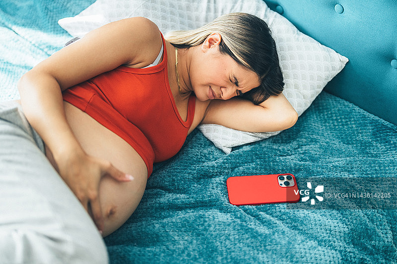 孕妇躺在床上感到疼痛图片素材