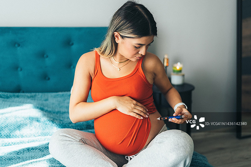 年轻孕妇用胰岛素笔注射胰岛素图片素材