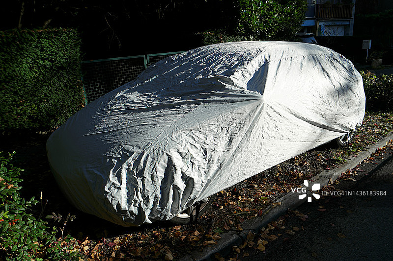秋季：停在室外的汽车，用罩子保护图片素材