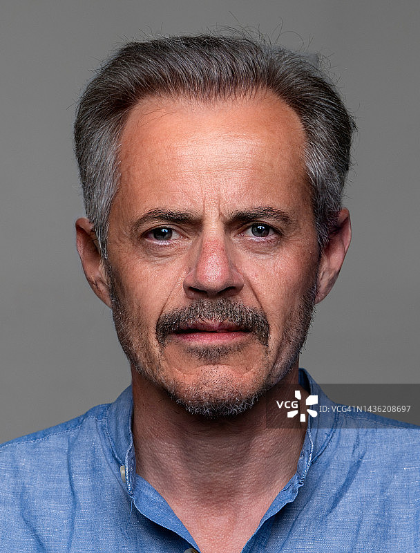 灰色背景上的严肃男人正面照图片素材